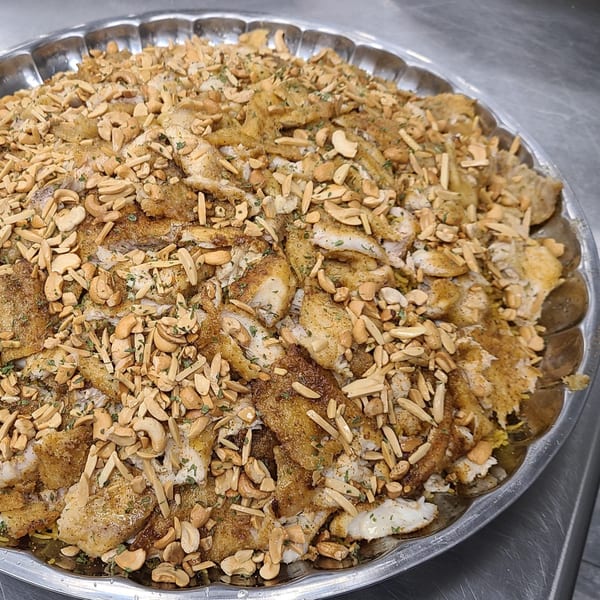Lebanese Sayadieh, a large platter of spiced fish and rice topped with toasted nuts.